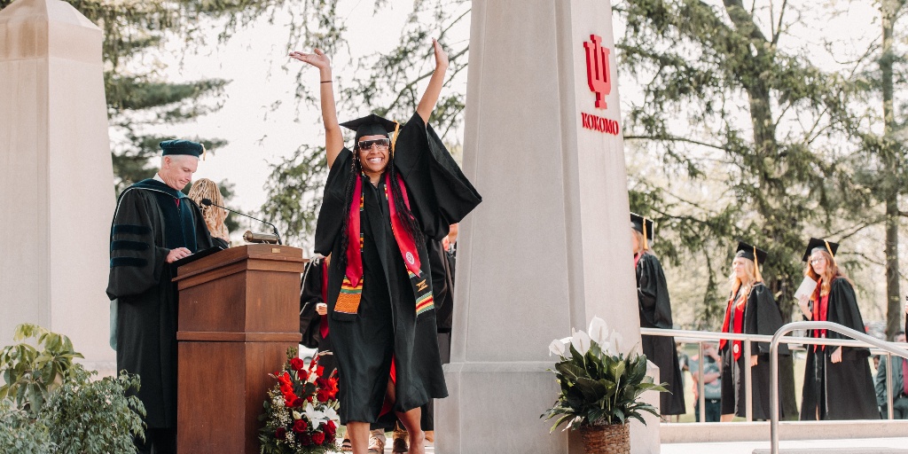 A graduate raising her arms.